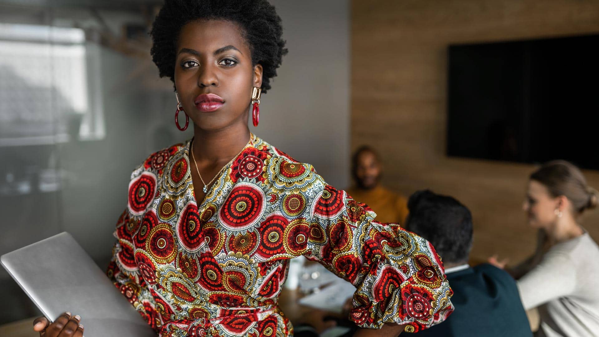 African American Woman standing and holding laptop